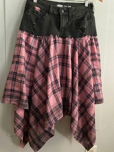 a pink and black plaid skirt hanging on a door