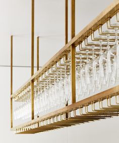 several wine glasses are lined up on a rack in front of a wall mounted light fixture