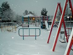 a snowy playground with swings and slides