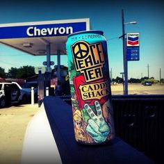 a can of beer sitting on the side of a gas station