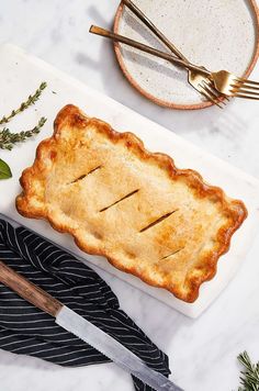 a piece of pie sitting on top of a white plate next to a knife and fork