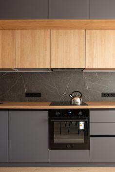 a stove top oven sitting inside of a kitchen next to wooden cupboards and counter tops