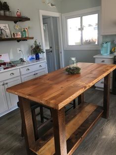 a wooden table sitting in the middle of a kitchen