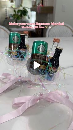 three starbucks beverages in small baskets on a table with pink ribbon and streamers around them