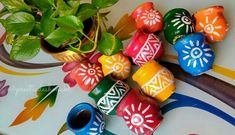 colorfully painted wooden beads sitting next to a potted plant