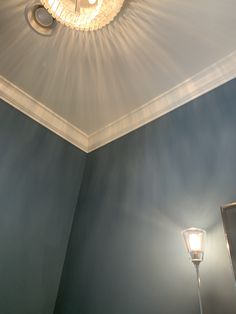 a light that is on in the corner of a room with blue walls and ceiling