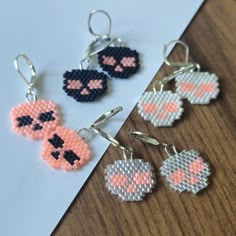 three pixel keychains are sitting on top of a piece of paper next to each other