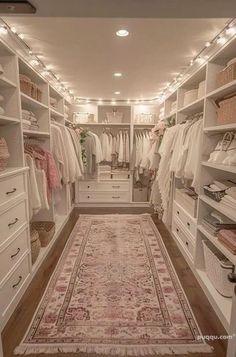 a walk in closet filled with lots of white furniture and hanging lights on the ceiling