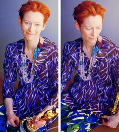 a woman with red hair is sitting on the floor and holding a piece of jewelry