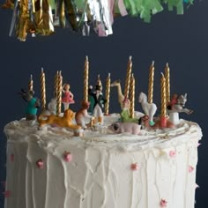 a white cake topped with lots of figurines on top of it's icing