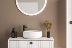 a white sink sitting under a round mirror on top of a counter next to a black faucet