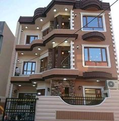 a tall brown and white building with lots of windows