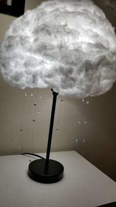 a white cloud is on top of a black stand