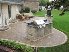 an outdoor kitchen with grill and seating area