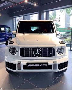 the front end of a white mercedes suv in a showroom