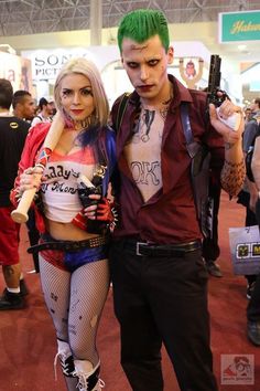 a man and woman dressed up in costumes at a convention or show, posing for the camera