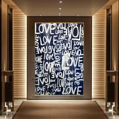 an art piece is displayed in front of a wall with the words love written on it