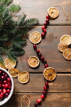 oranges, cranberries and pine cones are arranged in the shape of a heart