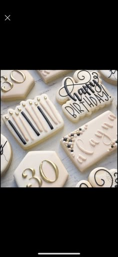 some decorated cookies are on a table with the words happy birthday written in black and white