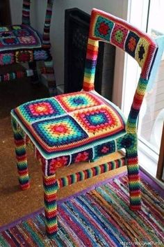 a crocheted chair sitting on top of a rug next to a fire place