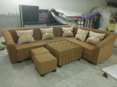 a couch with several pillows on it in a room that is being built into the floor