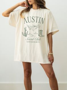 a woman wearing a white t - shirt with the words, austin on it