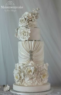 a three tiered wedding cake with white flowers on top