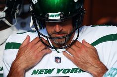 a close up of a football player adjusting his helmet