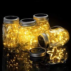 mason jars filled with fairy lights on a reflective surface