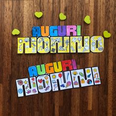 the word august is spelled with colorful magnets on a wooden surface, surrounded by hearts