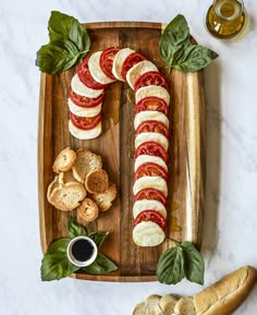 a wooden tray topped with sliced tomatoes and bread