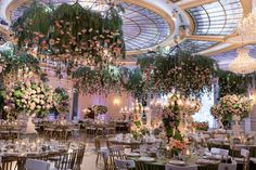 an elaborately decorated banquet hall with chandeliers and floral arrangements on the ceiling