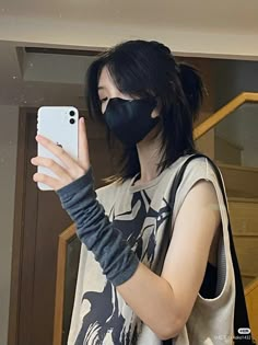 a woman wearing a face mask while holding a cell phone