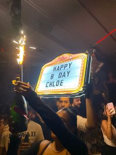 a group of people holding up a happy b day sign with sparklers in the air