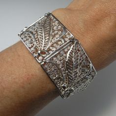 Here is an exceptional Art Nouveau completely handmade silver filigree bracelet circa 1890. The workmanship here is reminiscent of 18th century filigree in the quality and intricacy of this amazing piece. Each panel is entirely made by hand with silver wire twisted and wound into a fern and frond design each bouquet tied with a feminine bow. Amazingly each panel is not flat but the silver lace design is raised in relief with the central fern frond sitting higher to the rest of the panel. When th Elegant Luxury Antique Silver Cuff Bracelet, Antique Cuff Bracelet With Intricate Design For Formal Occasions, Wedding Filigree Bangle Bracelets, Elegant Etched Bangle For Wedding, Victorian Cuff Bracelet With Intricate Design, Victorian Cuff Bracelet With Intricate Design For Ceremonial, Victorian Cuff Bracelet With Intricate Design For Ceremonial Occasions, Victorian Cuff Bracelet With Intricate Design For Formal Events, Victorian Style Ceremonial Cuff Bracelet With Intricate Design