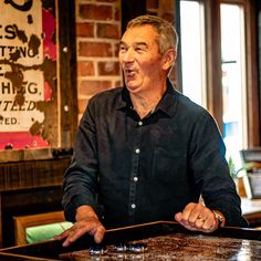 a man standing in front of a wooden table