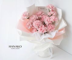 pink carnations are wrapped in white paper