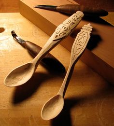 two spoons sitting on top of a wooden table