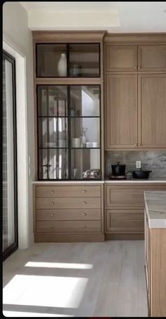 a kitchen with wooden cabinets and marble counter tops