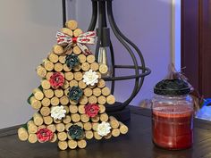 a christmas tree made out of wine corks on a table next to a candle