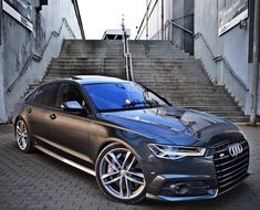 a grey car parked in front of some stairs