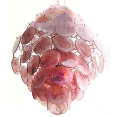 a chandelier made out of pink and white glass discs hanging from the ceiling