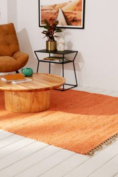 a living room with an orange rug and chair