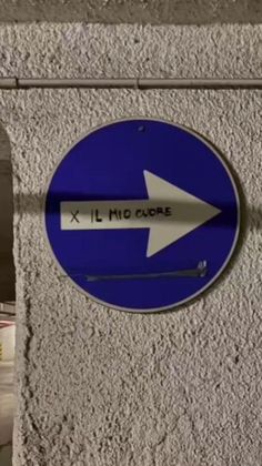 a blue sign with an arrow pointing to the left