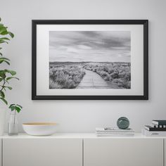 a black and white photo hanging on the wall next to a vase filled with flowers