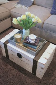 a coffee table with flowers in a vase on top