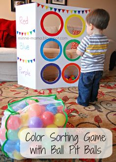 a little boy standing in front of a box filled with balls and playing with his toys