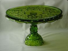 a green glass cake plate sitting on top of a table