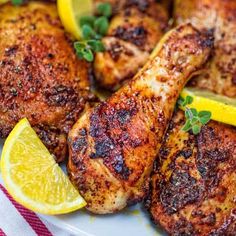 grilled chicken with lemon wedges and parsley on a white plate, ready to be eaten