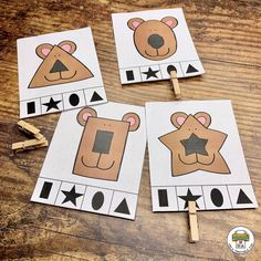 four bear themed cut outs on top of a wooden table next to clothes pegs